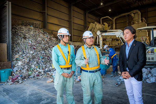 建設廃棄物の選別作業について説明を受ける河村さん。