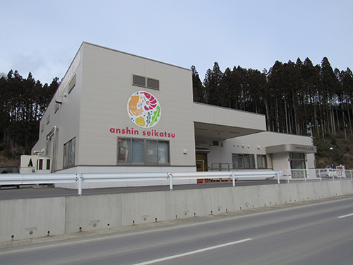 株式会社あんしん生活の外観。壁にあるロゴは海産物をちりばめたデザイン