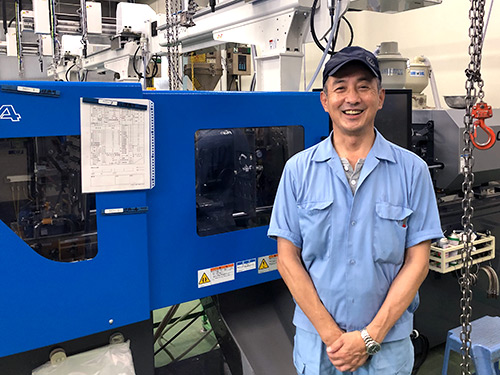 代表取締役の大塚順一さん。新設した射出成形機の前で。
